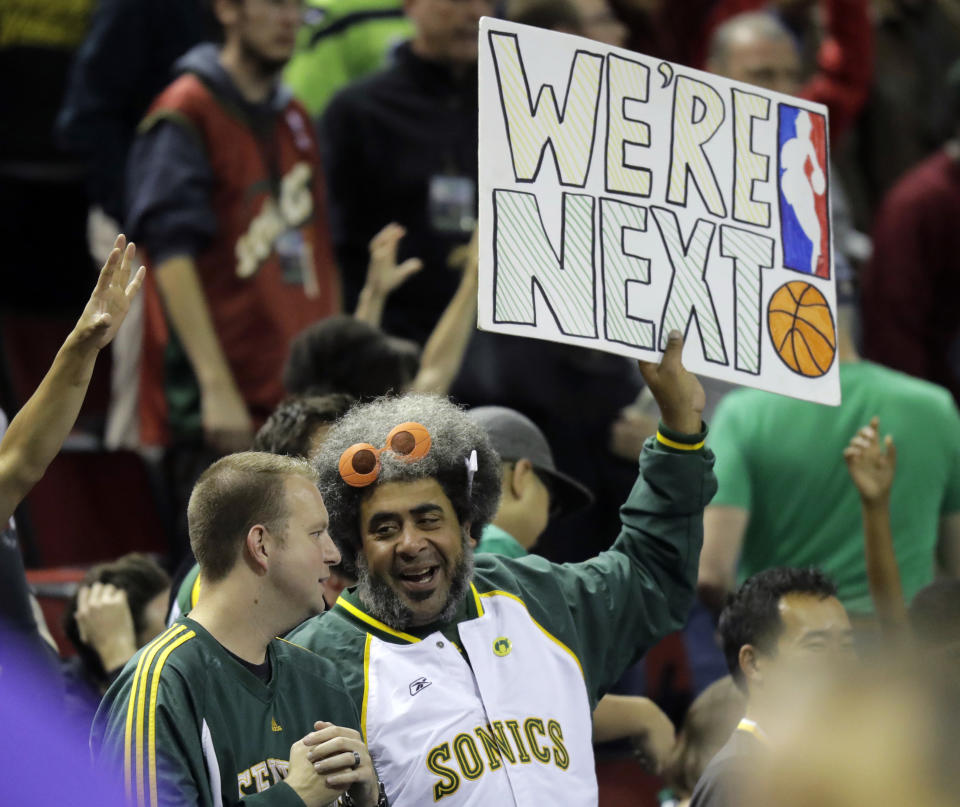 FILE - Kris "Sonics Guy" Brannon, right, holds a sign that reads "We're Next," as he attends an NBA basketball preseason game between the Golden State Warriors and the Sacramento Kings, Friday, Oct. 5, 2018, in Seattle. The NBA will make a return to the Emerald City on Monday night, when the Los Angeles Clippers face the Portland Trail Blazers in a preseason game. Seattle’s place in those expansion talks is at the top of the list with Las Vegas appearing to move into that second spot. But NBA Commissioner Adam Silver has been non-committal about a timeline for possible expansion. (AP Photo/Ted S. Warren, File)