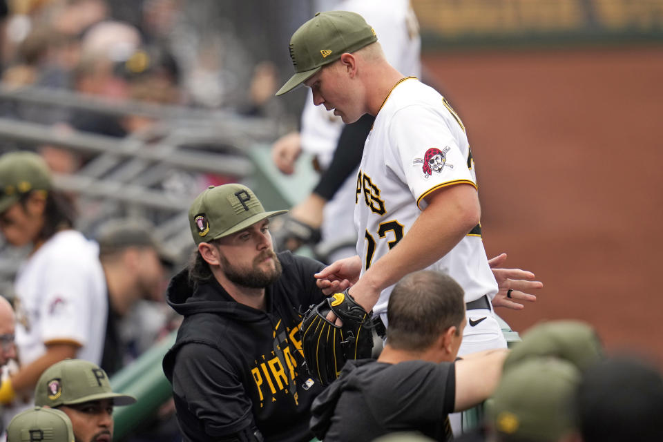 Pittsburgh Pirates starting pitcher Mitch Keller, top, is greeted at the dugout steps by J.T. Brubaker after pitching in the sixth inning of a baseball game against the Arizona Diamondbacks in Pittsburgh, Saturday, May 20, 2023. (AP Photo/Gene J. Puskar)