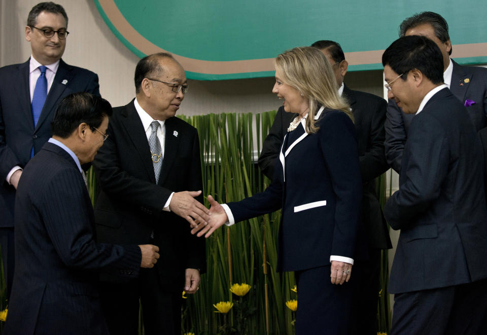 Thai Foreign Minister Surapong Tovichakchaikul shakes hands with U.S. Secretary of State Hillary Rodham Clinton during a group photo a East Asia Summit Ministerial Meeting at the Association of Southeast Asian Nations regional forum at Peace Palace in Phnom Penh, Cambodia Thursday, July 12, 2012. (AP Photo/Brendan Smialowski, Pool)
