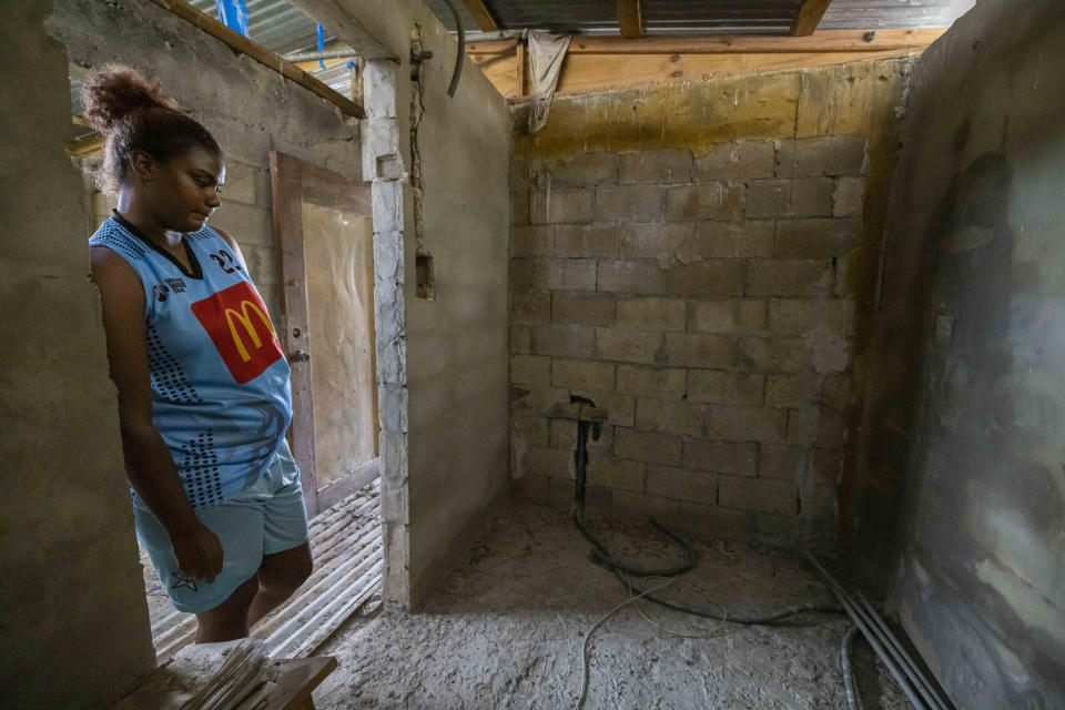 Jetsabel Osorio leans against a doorway in her hurricane-battered home, in Loiza, Puerto Rico, Thursday, Sept. 15, 2022. Nearly five years have gone by since Hurricane Maria struck Puerto Rico, no one has offered her family a plastic tarp or zinc panels to replace the roof that the Category 4 storm ripped off the two-story home tucked in an impoverished corner in the north coastal town of Loiza. (AP Photo/Alejandro Granadillo)