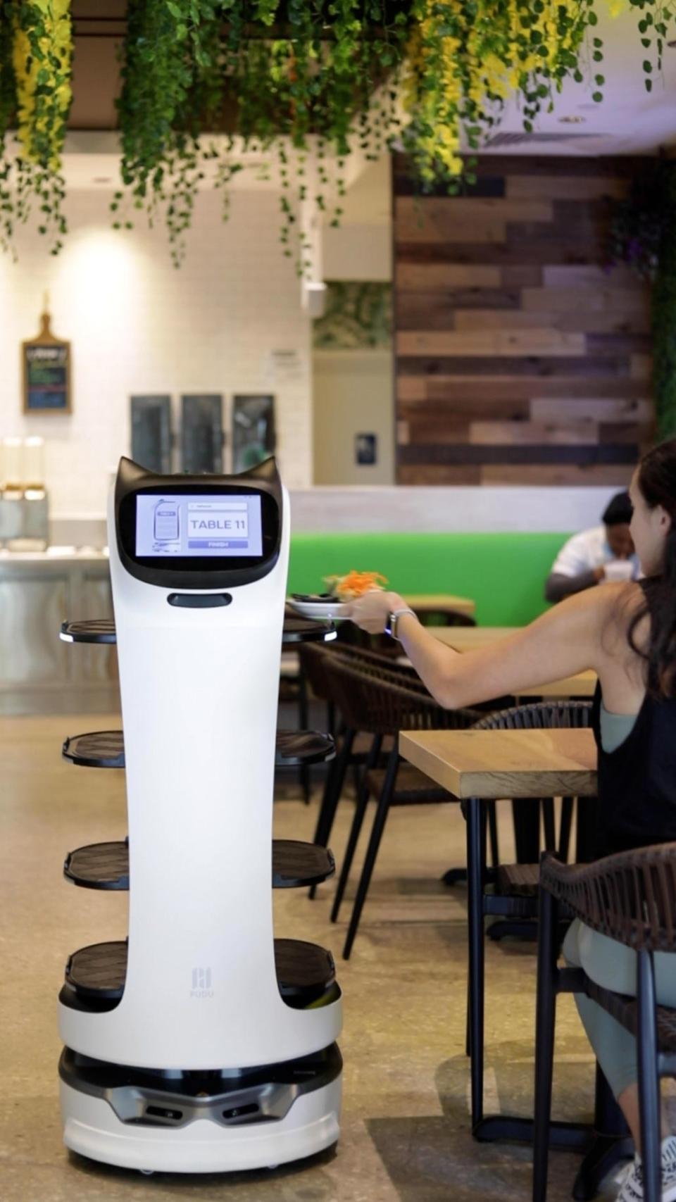A BellaBot delivers an order to a customer at Eat District in Boca Raton.