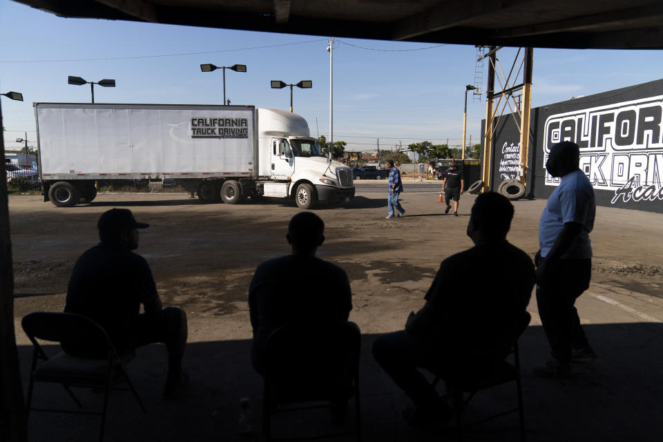 A group of student drivers wait for their turn to get behind the wheel at California Truck Driving Academy in Inglewood, Calif., Monday, Nov. 15, 2021. Amid a shortage of commercial truck drivers across the U.S., a Southern California truck driving school sees an unprecedented increase in enrollment numbers. The increase is big enough that the school is starting an evening class to meet the demand, according to Tina Singh, owner and academy director of California Truck Driving Academy. "I think that's only going to continue because there's a lot of job opportunities. We have over 100 active jobs on our job board right now," said Singh. The companies that normally would not hire drivers straight out of school are "100 percent" willing to hire them due to shortage issues, the director added. (AP Photo/Jae C. Hong)