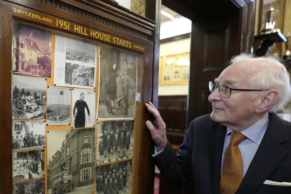 Richard Townend looks at old photographs, at Hill House School in London, a school where Britain's King Charles III was a pupil, Thursday, April 20, 2023. King Charles III hasn’t even been crowned yet, but his name is already etched on the walls of Hill House School in London. A wooden slab just inside the front door records Nov. 7, 1956, as the day the future king enrolled at Hill House alongside other notable dates in the school’s 72-year history. (AP Photo/Kirsty Wigglesworth)