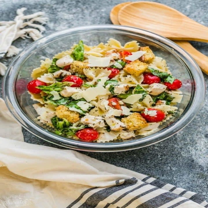 Chicken Caesar pasta salad in a mixing bowl.