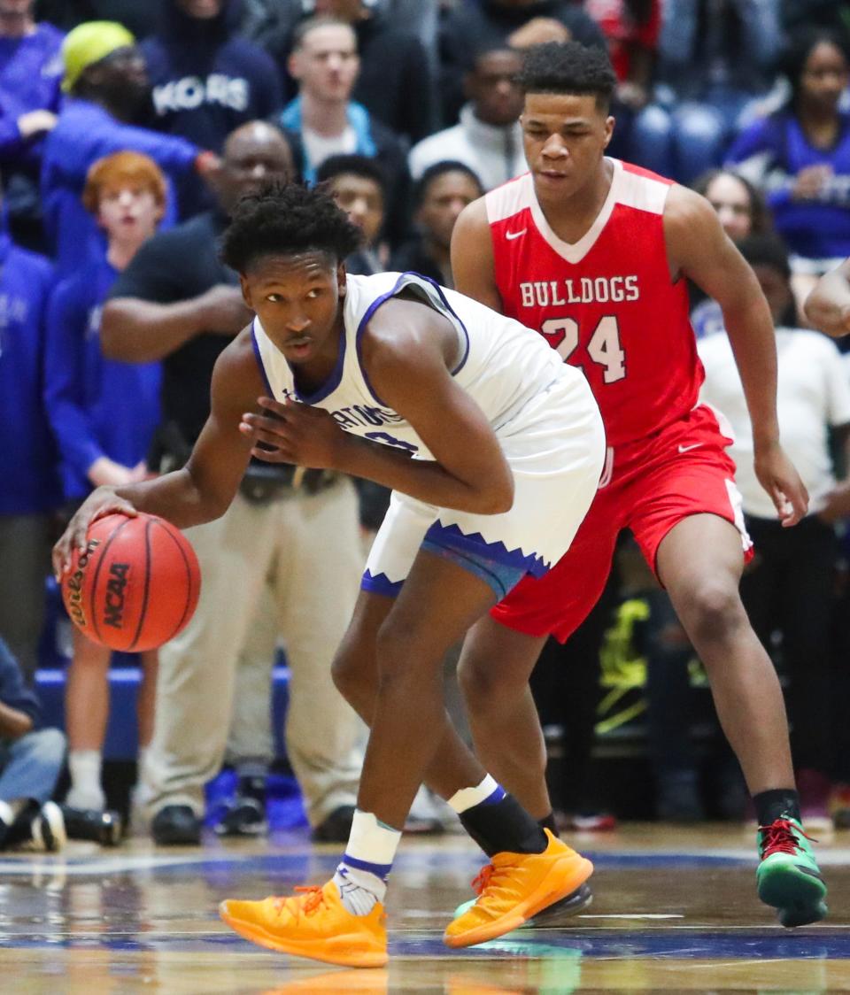 Corey Mumford, in the red uniform, defends against Dover's Eden Davis in a February 2020 game. Mumford was killed in a shooting on Friday.