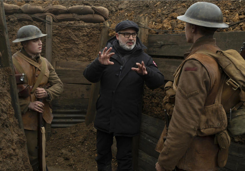 En esta imagen difundida por Universal Pictures, Dean-Charles Chapman, a la izquierda, el director Sam Mendes, en el centro, y George MacKay en el plató de "1917". (François Duhamel/Universal Pictures via AP)