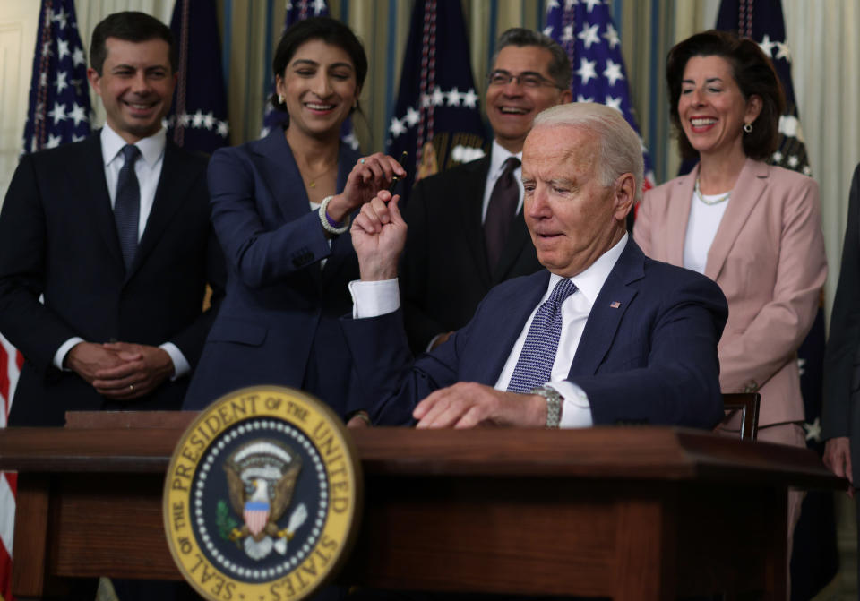 WASHINGTON, DC - JULI 09: USA:s president Joe Biden överlämnar en signaturpenna till ordföranden för Federal Trade Commission Lina Khan (2:a L) som (LR) transportsekreterare Pete Buttigieg, minister för hälsa och mänskliga tjänster Xavier Becerra och sekreterare för Handel Gina Raimondo tittar på under ett evenemang i Vita husets statliga matsal den 9 juli 2021 i Washington, DC. President Biden undertecknade en verkställande order om att "främja konkurrens i den amerikanska ekonomin." (Foto av Alex Wong/Getty Images)