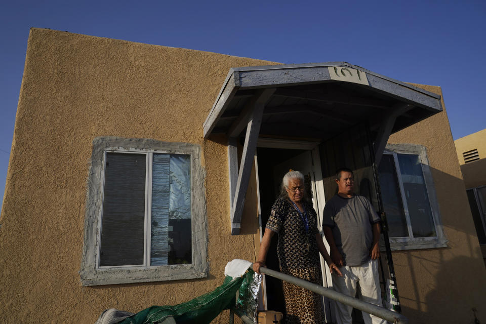 Maria Quintero, left, and her son J.J. stand outside the rental apartment they share in Calipatria, Calif., Friday, July 16, 2021. Quintero moved to the region from Mexicali, Mexico, in the early 1960s with her husband Agustin who was a bracero, or a seasonal migrant farm worker. The community near the shore of the Salton Sea, California's largest but rapidly shrinking lake, has been through decades of economic stagnation. Now, it's at the forefront of efforts to make the U.S. a major global producer of lithium, the ultralight metal used in rechargeable batteries. (AP Photo/Marcio Jose Sanchez)