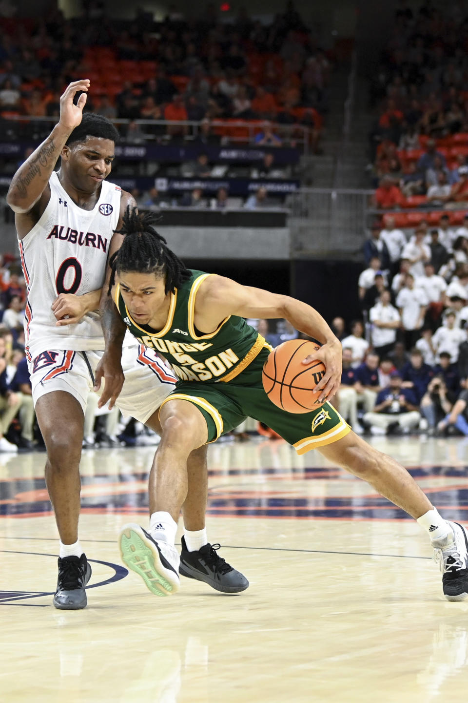 George Mason guard Devin Dinkins (5) drives past Auburn guard K.D. Johnson (0) during the second half of an NCAA college basketball game Monday, Nov. 7, 2022, in Auburn, Ala. (AP Photo/Julie Bennett)