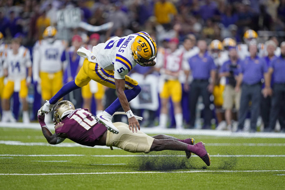 FILE - LSU quarterback Jayden Daniels (5) is upended by Florida State defensive back Jammie Robinson (10) on a carry in the second half of an NCAA college football game in New Orleans, Sunday, Sept. 4, 2022. Florida State won 24-23. The two teams will face each other again on Sept. 3, 2023, in Orlando, Florida, in a game that will be aired on ABC. (AP Photo/Gerald Herbert, File)