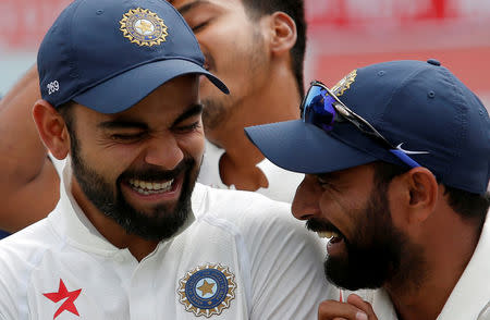 Cricket - India v Australia - Fourth Test cricket match - Himachal Pradesh Cricket Association Stadium, Dharamsala - 28/03/17 - India's Virat Kohli and Mohammed Shami (R) shares a moment during an award ceremony after winning the series. REUTERS/Adnan Abidi