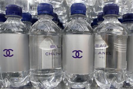 Chanel mineral bottles are displayed on supermarket shelves at the Grand Palais transformed into a "Chanel Shopping Center" after the German designer Karl Lagerfeld Fall/Winter 2014-2015 women's ready-to-wear collection show for in French fashion house Chanel during Paris Fashion Week March 4, 2014. REUTERS/Benoit Tessier