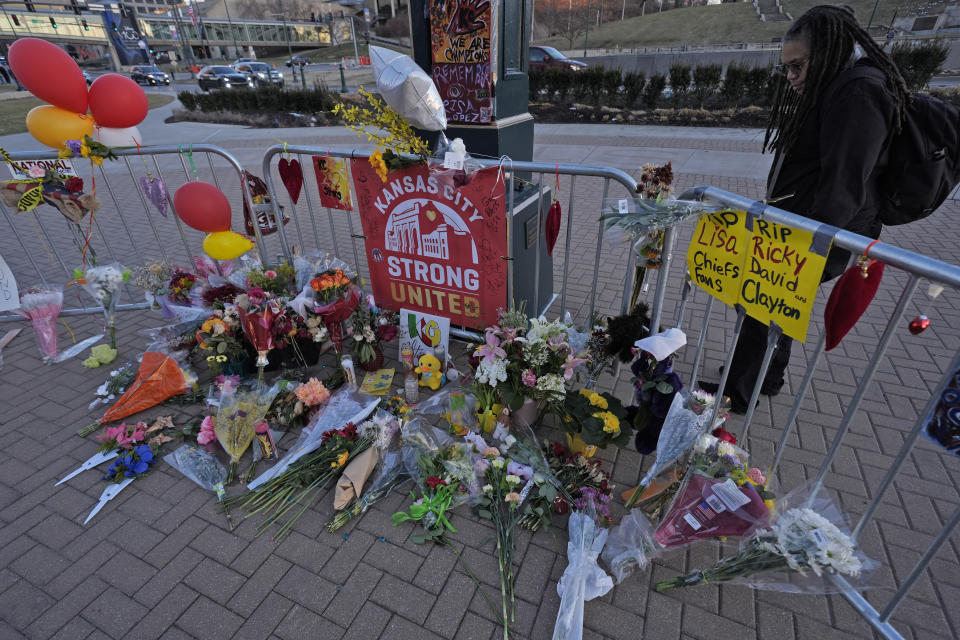 FILE - A person views a memorial dedicated to the victims of last week's mass shooting in front of Union Station, Sunday, Feb. 18, 2024, in Kansas City, Mo. Missouri prosecutors said Tuesday, Feb. 20, that two men have been charged with murder in last week’s shooting that killed one person and injured multiple others after the Kansas City Chiefs’ Super Bowl parade. (AP Photo/Charlie Riedel, File)