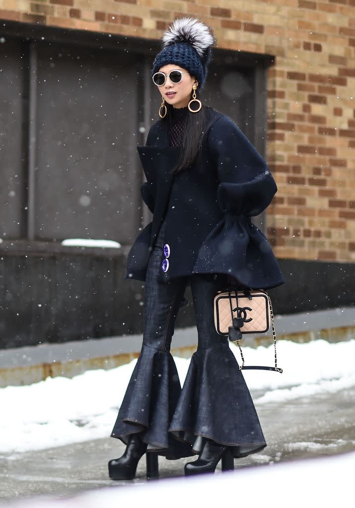 <p>If you love risks, embrace exaggerated details, from your coat all the way down to your hemline. Go for drama with high-heeled platform boots, a statement purse, earrings, and furry pom-pom hat. (Photo: Getty Images) </p>