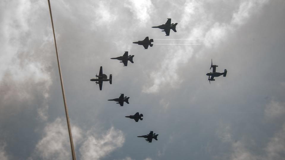 Aircraft from the Nimitz Carrier Strike Group and the Makin Island Amphibious Ready Group fly in formation over the aircraft carrier Nimitz on Feb. 15, 2023, in the South China Sea. (MC3 Caylen McCutcheon/U.S. Navy)