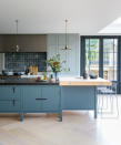 <p> In a large room, a separate kitchen island and dining area can appear disconnected and mean the space lacks a focal point to gather around. Yet an oversized block in the center of the room can dominate the space. </p> <p> In this kitchen, designed by Mowlem & Co, the solution is to create two-material island that encompasses a workspace, informal bar-stool dining, and a huge prep area. </p> <p> Pendant lights define each side of the structure and add a decorative element to the space. </p>
