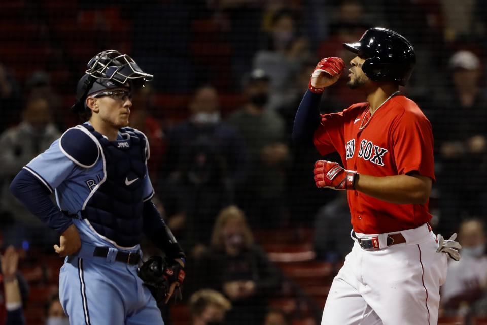 As Toronto Blue Jays catcher Danny Jansen looks on, Boston Red Sox's Xander Bogaerts blows a kiss while crossing the plate after his three-run home run during the fourth inning of a baseball game Tuesday, April 20, 2021, at Fenway Park in Boston. (AP Photo/Winslow Townson)