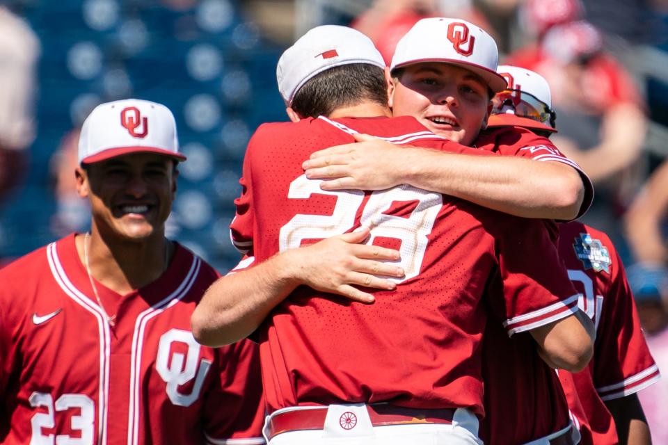 Jun 22, 2022; Omaha, NE, USA; Oklahoma Sooners starting pitcher David Sandlin (28) hugs pitcher Carson Atwood (34) after defeating the Texas A&M Aggies at Charles Schwab Field. Mandatory Credit: Dylan Widger-USA TODAY Sports