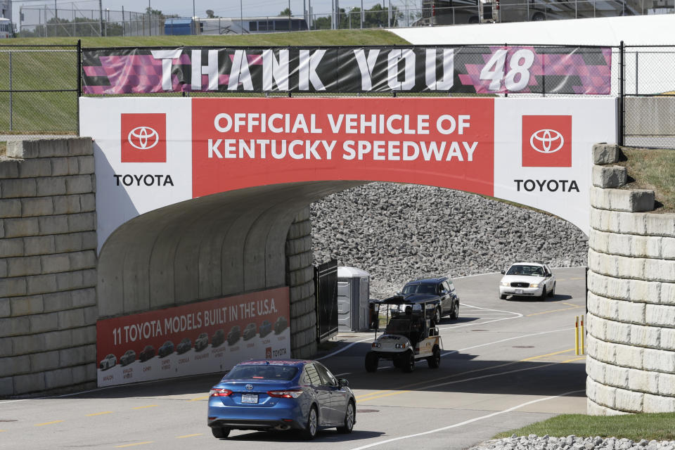 An entrance sign for Kentucky Speedway is decorated with a banner honoring driver Jimmie Johnson before a NASCAR Cup Series auto race Sunday, July 12, 2020, in Sparta, Ky. NASCAR's nicest guy will run his final race this week and close a remarkable career. Jimmie Johnson's record-tying seven Cup titles are well celebrated, but his charitable work goes less noticed. The Jimmie Johnson Foundation has donated more than $12 million to schools and programs since it launched. (AP Photo/Mark Humphrey)