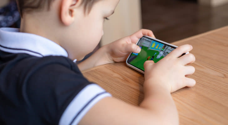 A child playing Roblox on a smartphone.