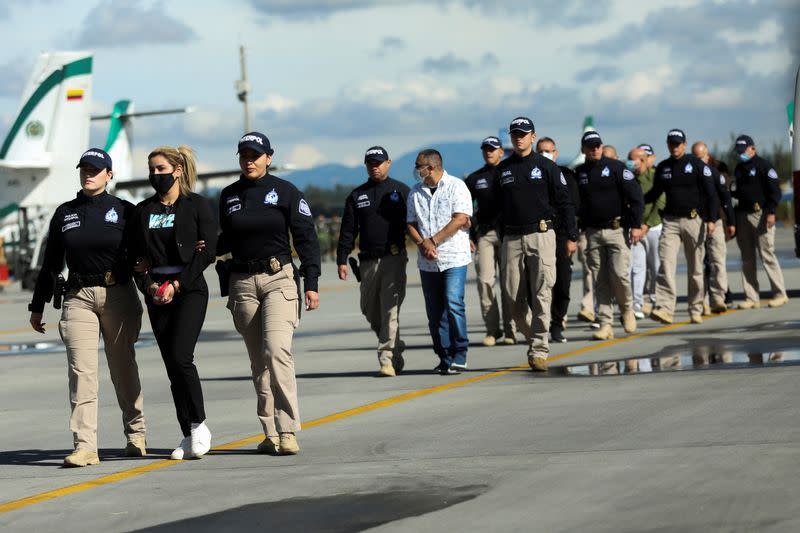 Colombian National Police officers escort Nini Johana Usuga, alias 'La Negra', at the Military Transport Air Command (CATAM) in Bogota