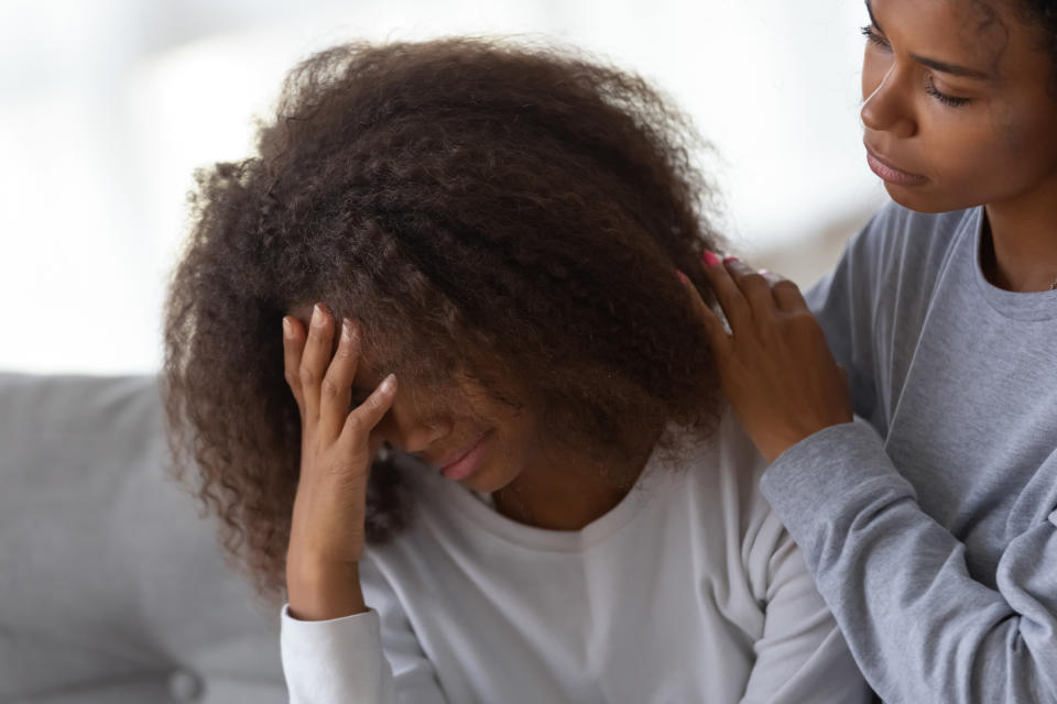 Young African American mom hug disappointed sad teenage daughter, caressing and comforting her, black teen girl feel down, suffer from school problems, mommy or nanny embrace and support