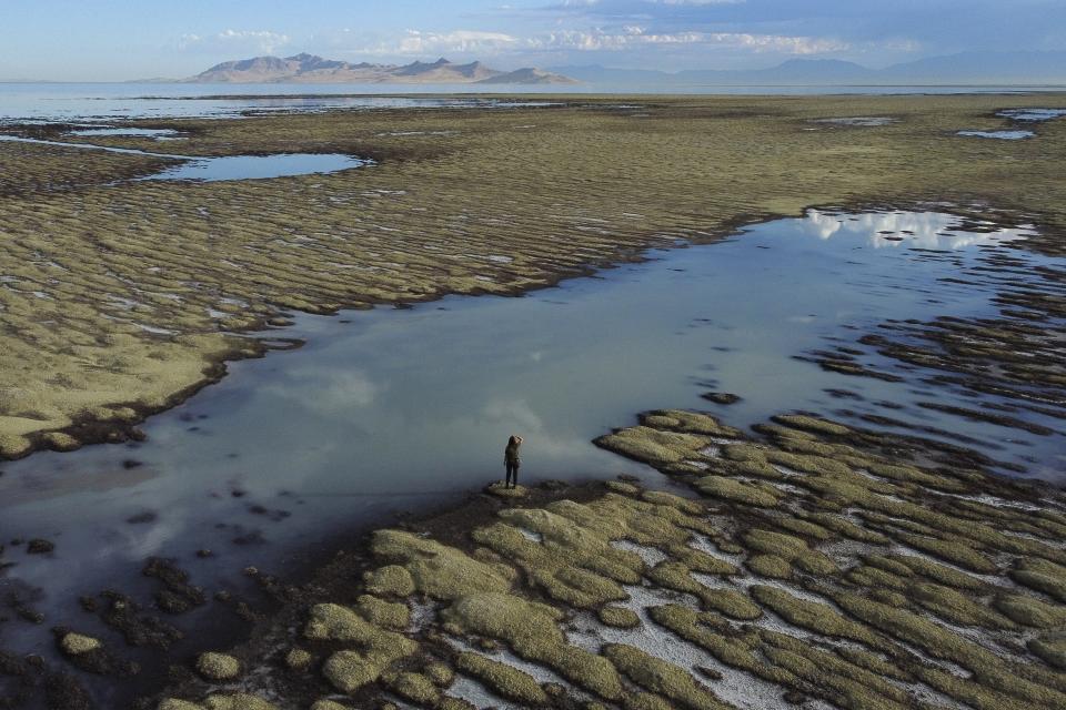 State of Utah Department of Natural Resources park ranger Angelic Lemmon walks across reef-like structures called microbialites, exposed by receding waters, at the Great Salt Lake, near Salt Lake City, on Sept. 28, 2022. (AP Photo/Rick Bowmer)