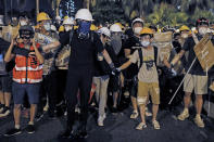 In this Sunday, July 14, 2019, photo, protesters wearing protection gears as they prepare to face-off with policemen on a street in Sha Tin District in Hong Kong. What began as a protest against an extradition bill has ballooned into a fundamental challenge to the way Hong Kong is governed _ and the role of the Chinese government in the city’s affairs. (AP Photo/Kin Cheung)
