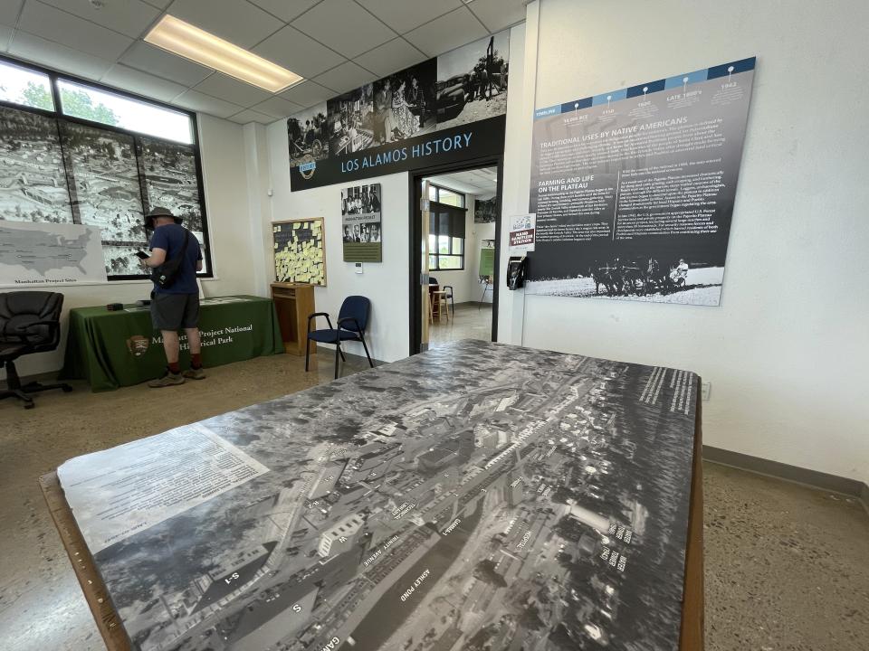 A tourist looks at a display inside the Manhattan Project National Historical Park visitor center in Los Alamos, N.M., on Aug. 13, 2023. Almost overnight, Los Alamos was transformed to accommodate the scientists and soldiers who developed the world's first atomic bomb during World War II. The community is facing growing pains again, 80 years later, as it works to modernize the country's nuclear arsenal. (AP Photo/Susan Montoya Bryan)