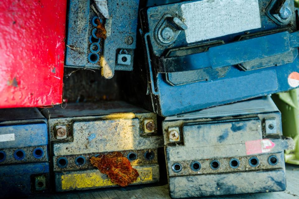 A pile of car batteries in assorted colors to be recycled. 