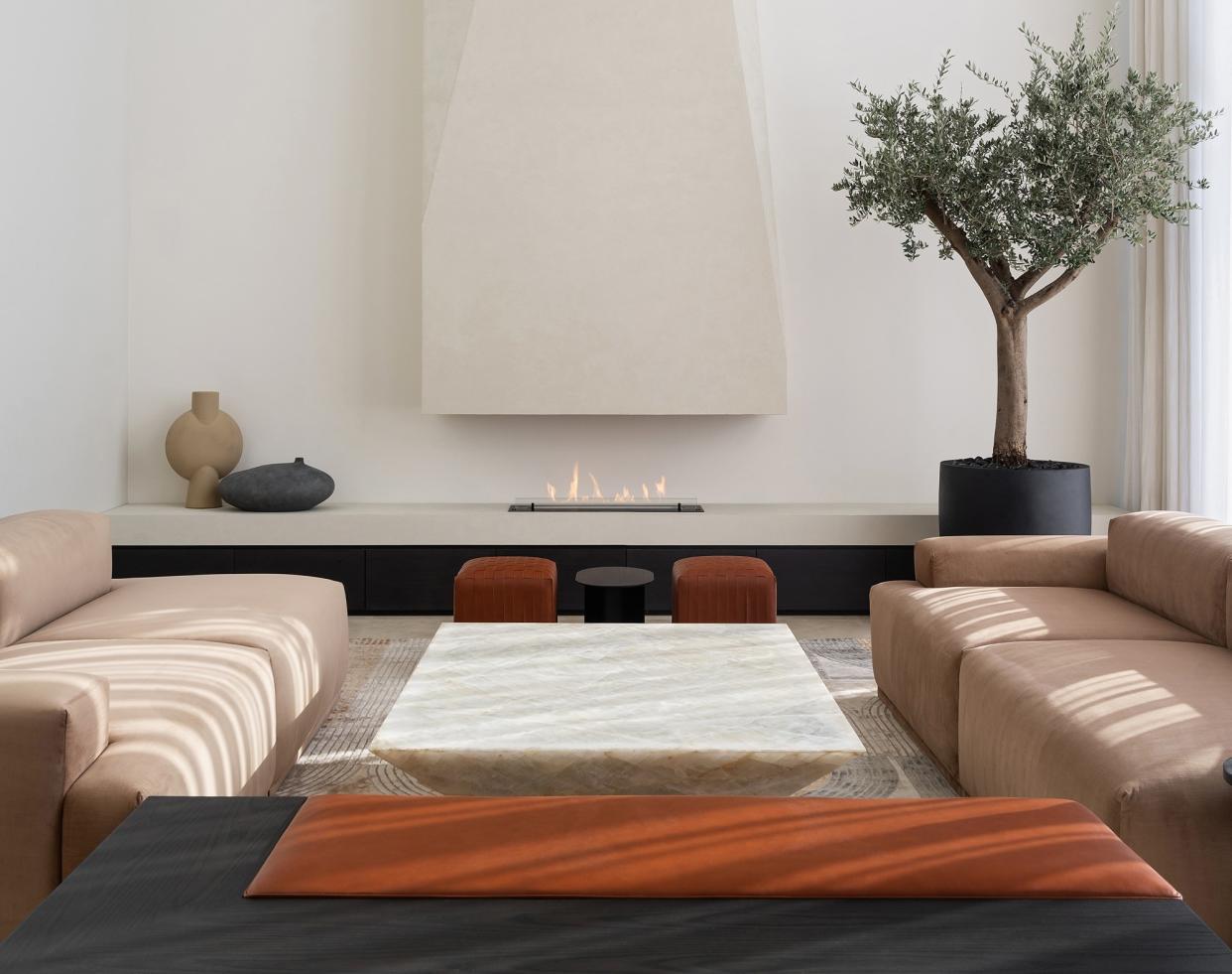  A living room in muted tones, with a tree in the corner. 