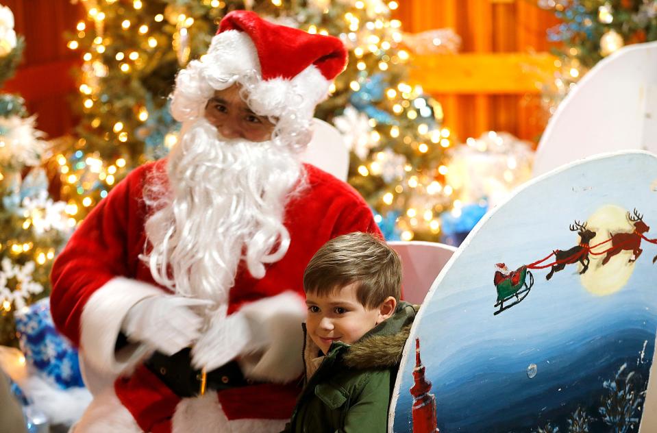 Owen Kudla visits with Santa at Richland Carrousel Park during Christmastime in the City in downtown Mansfield on Friday, Dec. 2, 2022. TOM E. PUSKAR/ASHLAND TIMES-GAZETTE