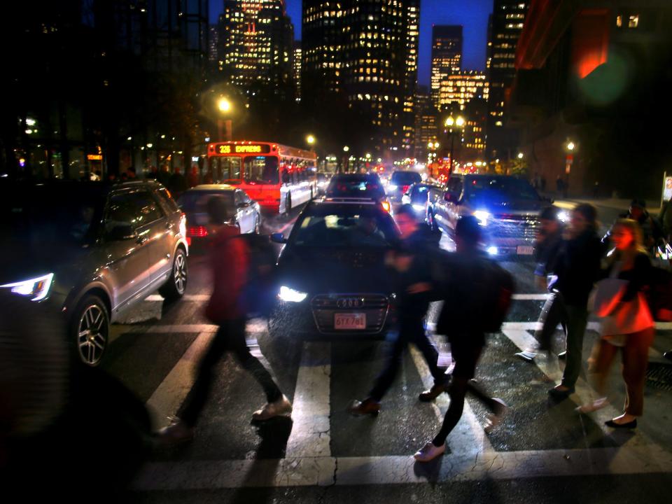 Pedestrians cross in front of backed up traffic on Congress Street in Boston near Government Center on Oct. 30, 2019.