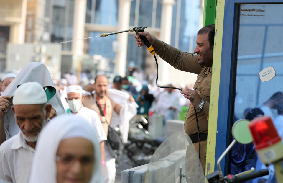 A Saudi policeman spays pilgrims