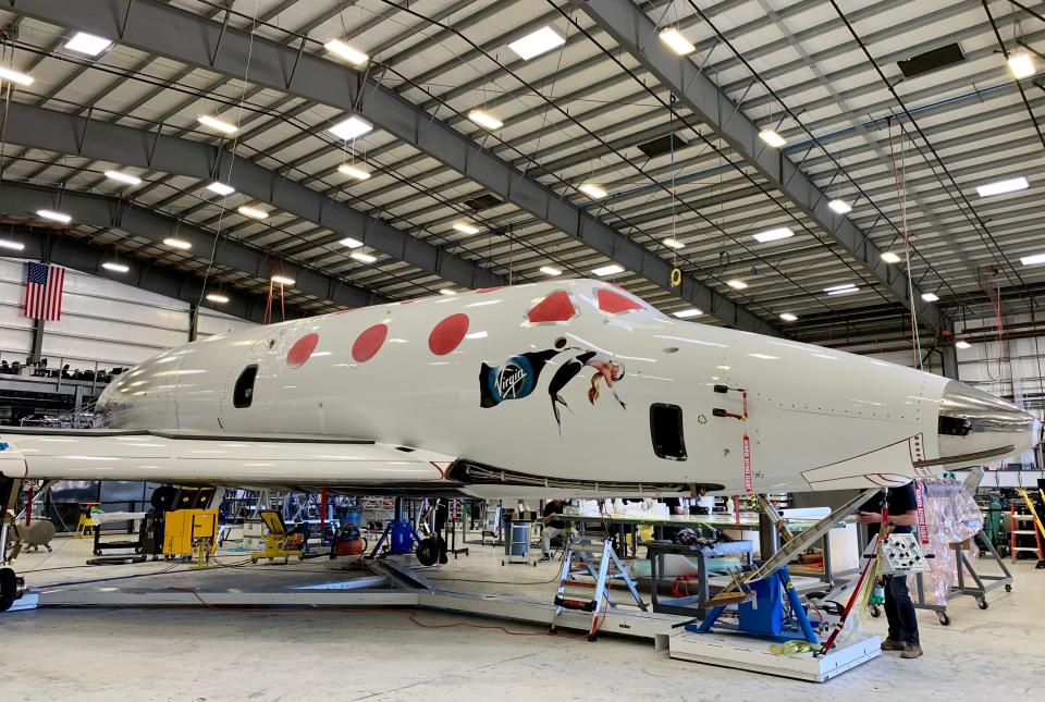 Virgin Galactic's SpaceShipTwo, also known as VSS Unity, undergoes checks before its next test flight at the company's private facility in Mojave, California. The illustration of the woman floating in space on the fuselage is said to be drawn from a youthful photo of founder Richard Branson's mother, Eve. The spaceship looks like a cross between a Gulfstream jet and something out of 'Star Trek.'