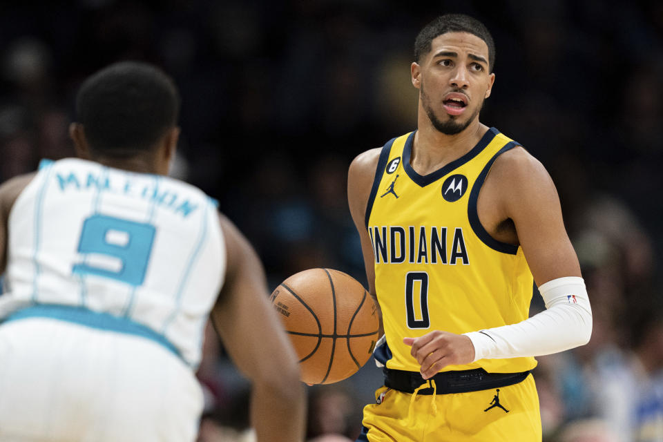 Indiana Pacers guard Tyrese Haliburton (0) brings the ball up while guarded by Charlotte Hornets guard Theo Maledon (9) during the second half of an NBA basketball game in Charlotte, N.C., Wednesday, Nov. 16, 2022. (AP Photo/Jacob Kupferman)