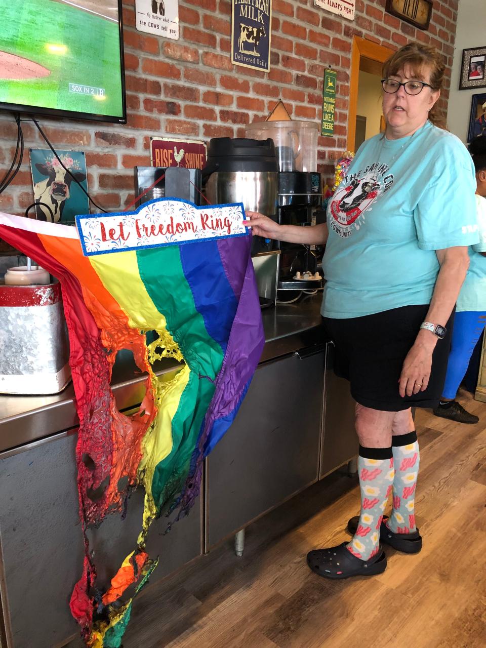 Sailing Cow restaurant owner Robyn Thibodeau with burned Pride flag on Friday in Dennis Port.