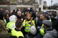 FILE - In this Jan.15, 2019 file photo, Ingrid Levavasseur, center, one of the leading figures of France's Yellow Vests protests, talks to residents and protestors as she waits for French President Emmanuel Macron's visit in Bourgtheroulde, Normandy. The blaze at Notre Dame has sent a shockwave through France, but Levavasseur believes that the image of unbroken national unity felt in the aftermath of the fire is politically exploited by Macron. (AP Photo/Francois Mori, File)