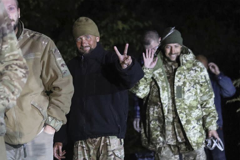 En esta imagen publicada por la Oficina de Prensa del Servicio de Seguridad de Ucrania, soldados ucranianos liberados en un canje de prisioneros entre Rusia y Ucrania sonríen cerca de Chernígov, Ucrania, la noche del miércoles 21 de septiembre de 2022 (Oficina de Prensa del Servicio de Seguridad de Ucrania via AP)