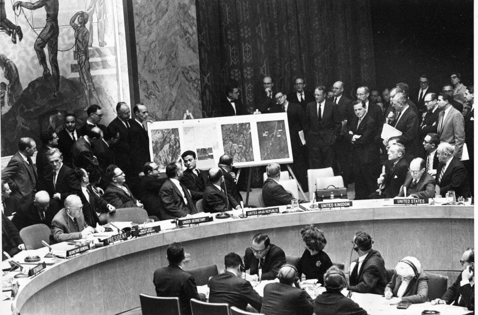 U.S. Ambassador to the United Nations, Adlai Stevenson, second from right, confronts Soviet delegate Valerian Zorin, first on left, with a display of reconnaissance photographs during an emergency session of the U.N. Security Council at the United Nations headquarters in New York, on Oct. 25, 1962. The photographs put emphasis on U.S. accusations of the placement of Soviet offensive missiles in Cuba.