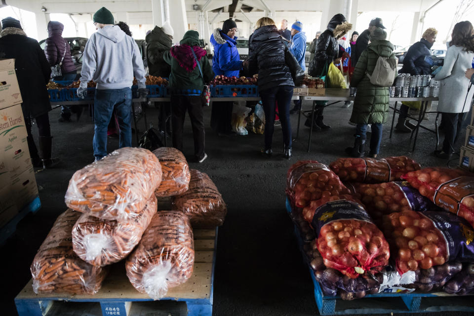 Philabundance volunteers distribute food to furloughed federal workers and their families who are affected by the partial government shutdown, under Interstate 95 in Philadelphia, Wednesday, Jan. 23, 2019. (AP Photo/Matt Rourke)