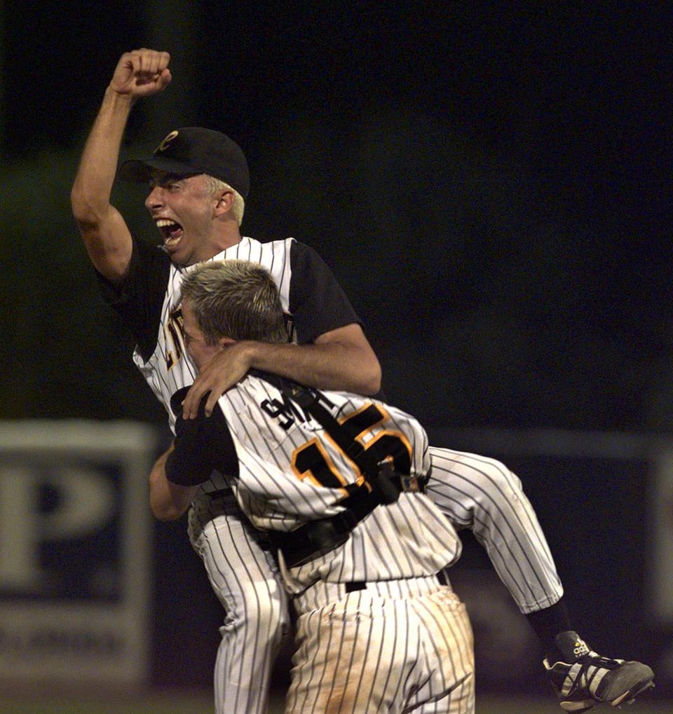 Englewood pitcher Charlie Farah (8) pumps his fist and yells as he is lifted into the air by catcher Jon Smith (15) after striking out the last Monsignor Pace batter to win the 1999 Class 4A FHSAA baseball title.
