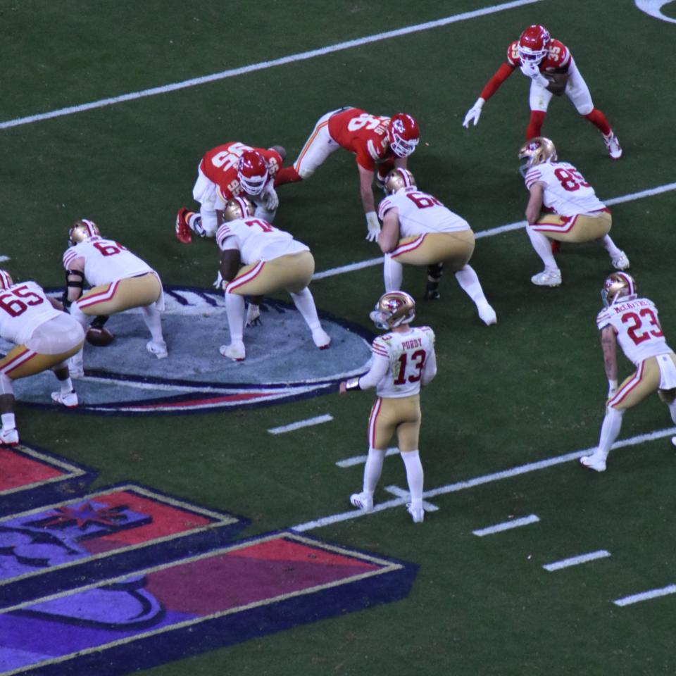 Brock Purdy and Christian McCaffrey waiting for the play to start