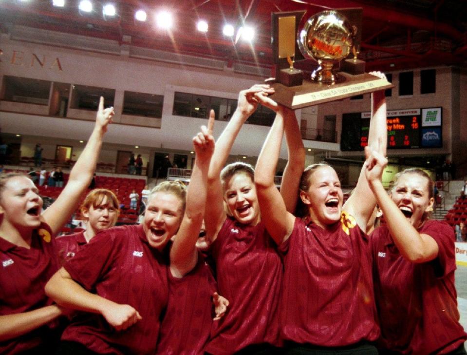 Evan Unrau, second from right, holds the trophy high over her head after Rocky Mountain High School beat Cherry Creek High for the Colorado Class 5A volleyball championships in Denver Saturday Nov. 12, 1999.