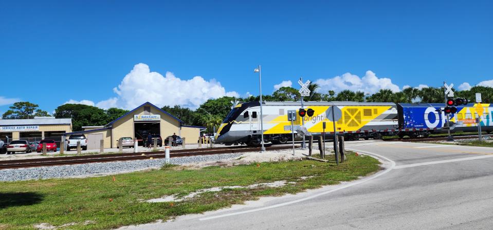 A northbound Brightline train passes by A1 Auto Care in Hobe Sound on Friday, Sept. 22, the first day of passenger service between Miami and Orlando.