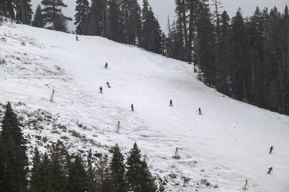 Skiers glide down a slope at Palisades Tahoe on Thursday, Dec. 21, 2023. Many Tahoe-area ski resorts lack open terrain due to limited snowfall.