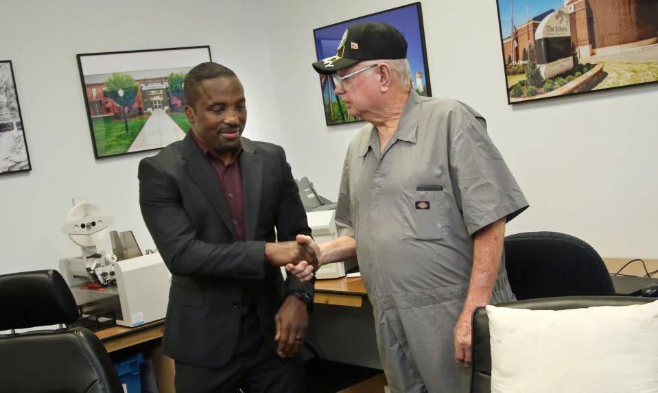 Ronnie Laws, left, is congratulated by Corey Creech after he won the coin flip for Ranlo Town Commissioner Friday afternoon at the Gaston County Board of Elections on West Franklin Boulevard.