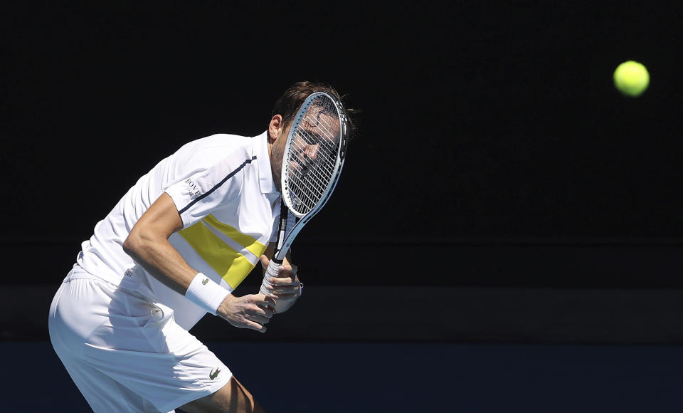 Russia's Daniil Medvedev hits a backhand to United States' Mackenzie McDonald during their fourth round match at the Australian Open tennis championships in Melbourne, Australia, Monday, Feb. 15, 2021. (AP Photo/Hamish Blair)