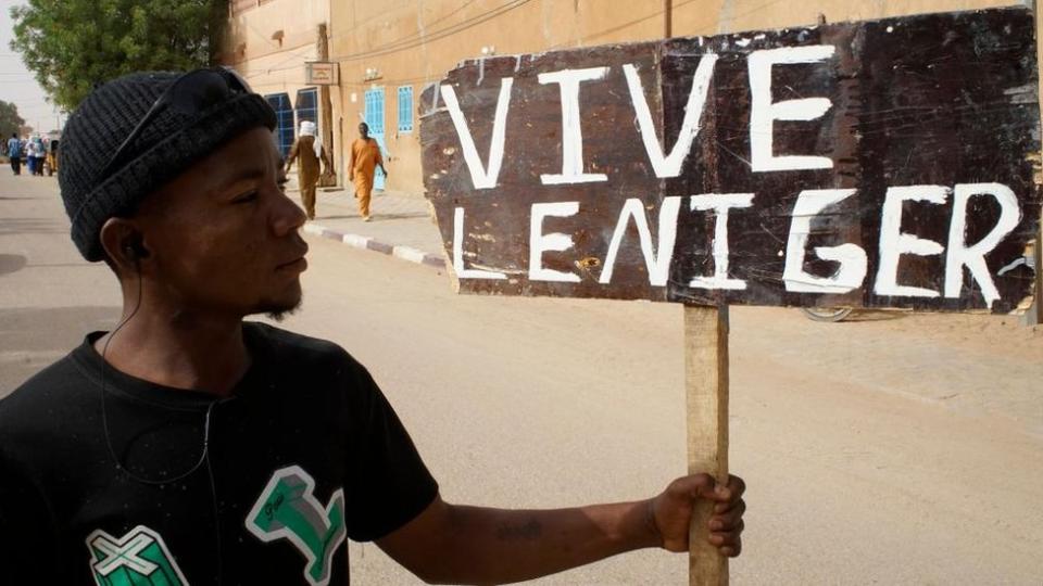 A protester holds a sign reading 