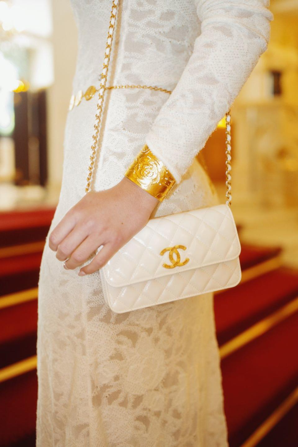 a person wearing a white dress and gold jewelry
